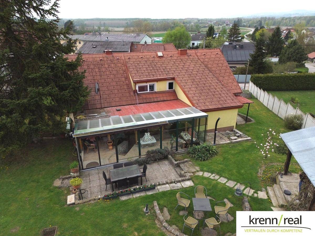 Vogelperspektive des Hauses mit Wintergarten, Terrasse und großem Garten, umgeben von der Nachbarschaft.