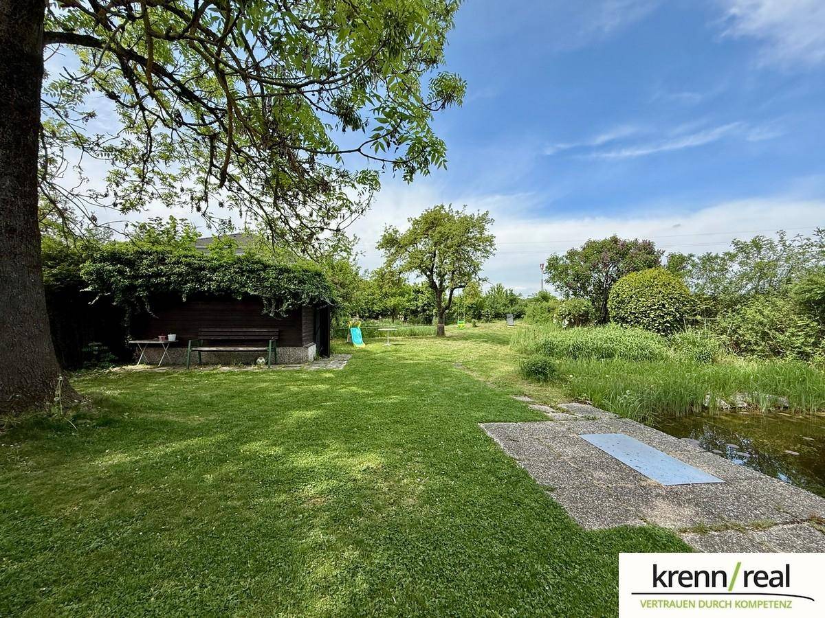 Großer, gepflegter Garten mit Teich, altem Baumbestand und Gartenhaus.