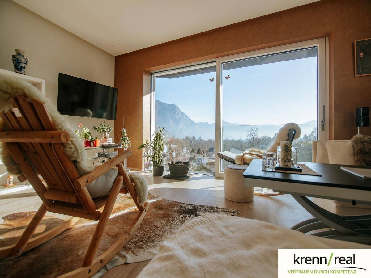 Gemütliches Wohnzimmer mit Bergblick, Holzboden und bequemen Sitzgelegenheiten.