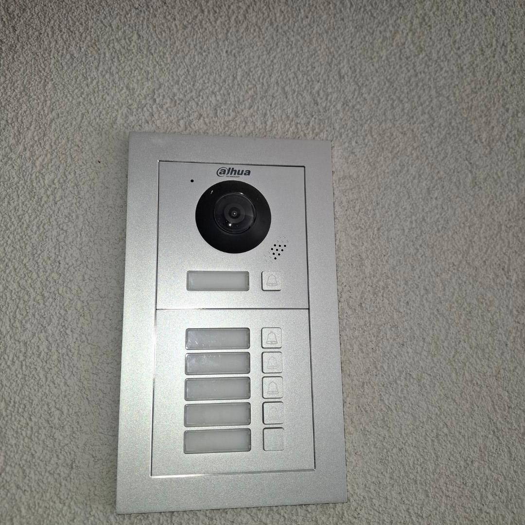 Außen-Sprechanlage mit Kamera und mehreren Klingeltasten für ein Mehrfamilienhaus.