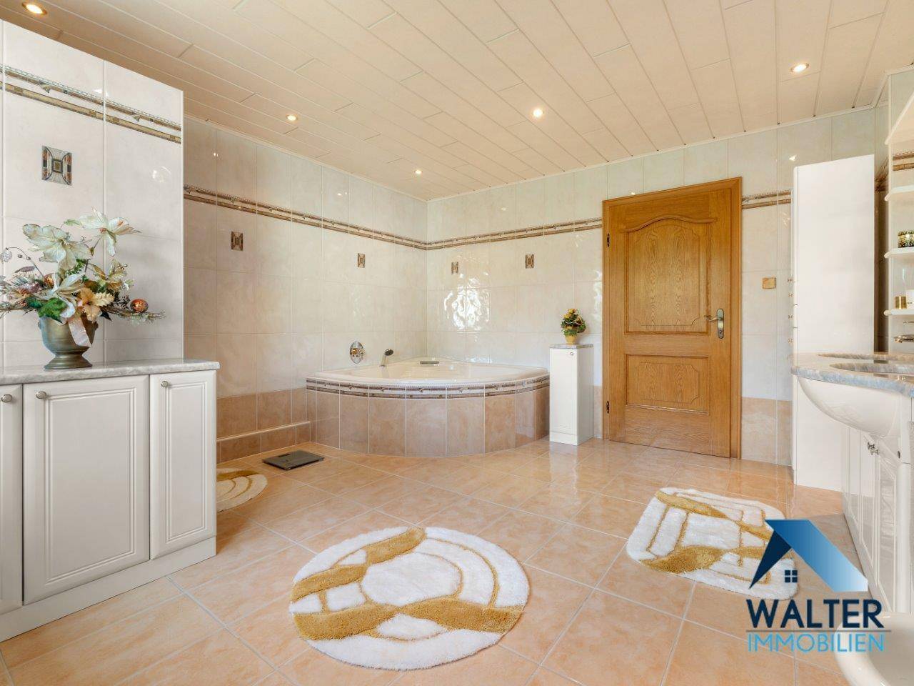 Helles Badezimmer mit Whirlpool-Badewanne und Doppelwaschbecken, ausgestattet mit Fliesenboden.