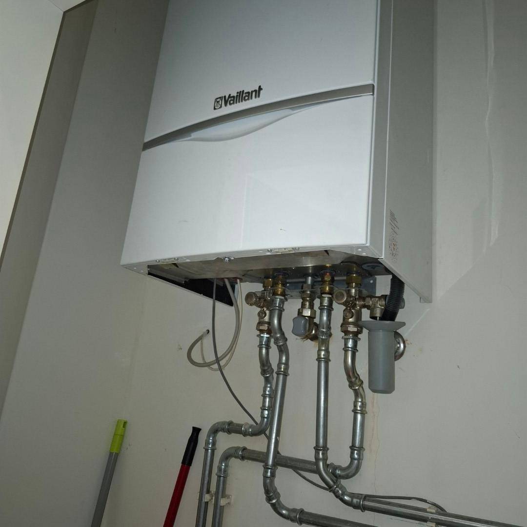 Wandmontierter Vaillant Heizkessel mit sichtbaren Rohrleitungen in einem funktionalen Technikraum.