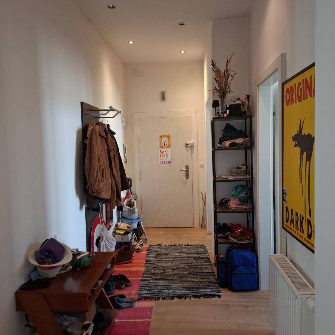 Heller Flur mit Garderobe, Schuhregal und Eingangstür, die zum Wohnbereich führt und einladend wirkt.