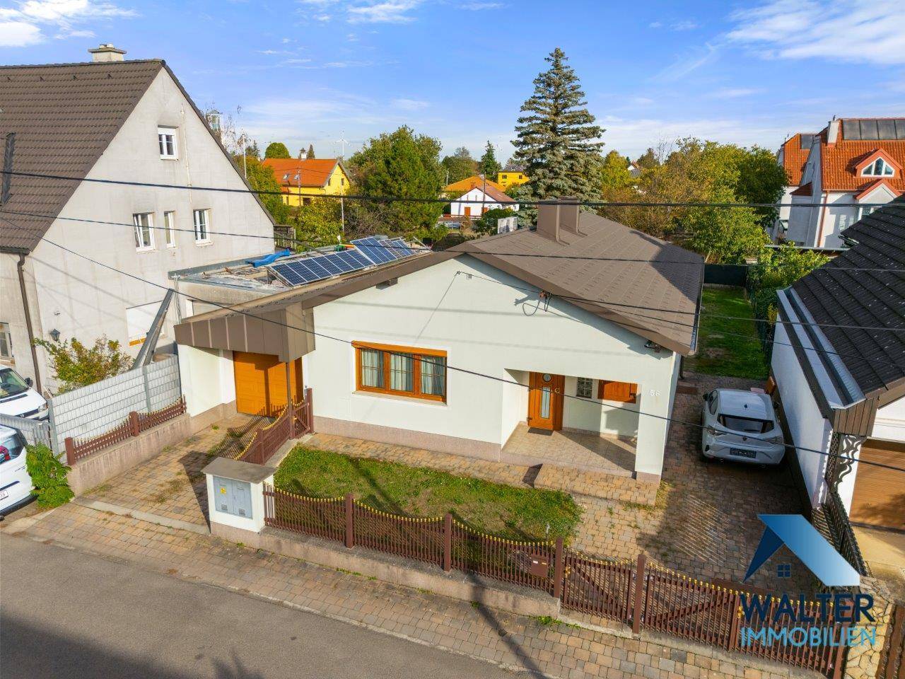 Vorderansicht des Hauses mit Vorgarten und Einfahrt, umgeben von einer kleinen Hecke.