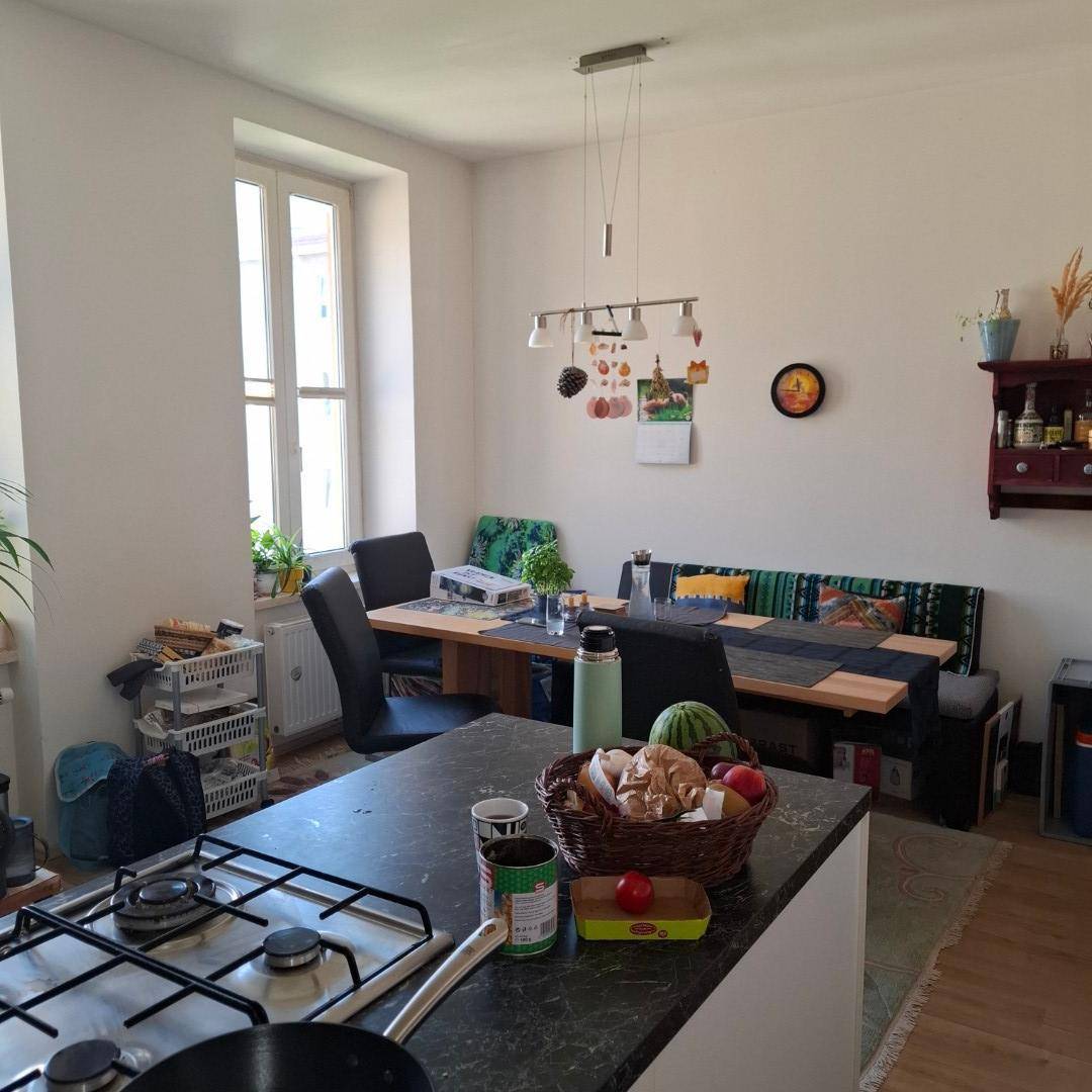 Wohnküche mit Essbereich, Kochinsel und gemütlicher Sitzbank am Esstisch, ideal für Familienmahlzeiten.