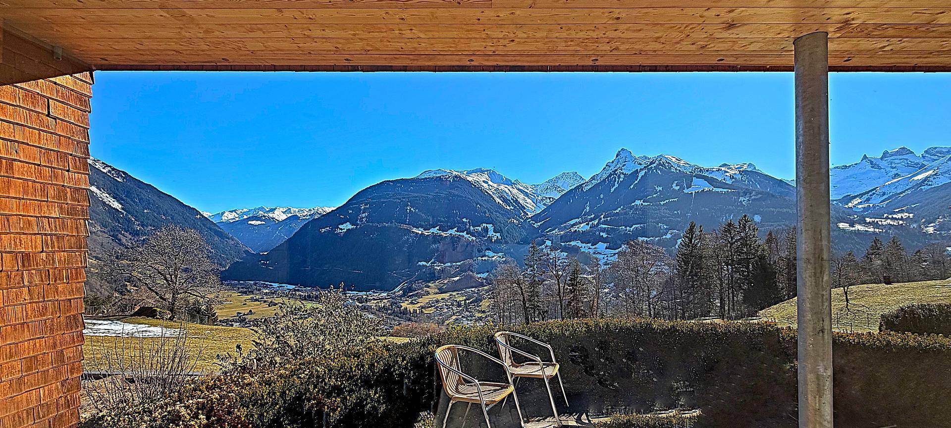Gemütlicher Außenbereich mit Sitzgelegenheiten und einem weiten Blick auf die Bergwelt.