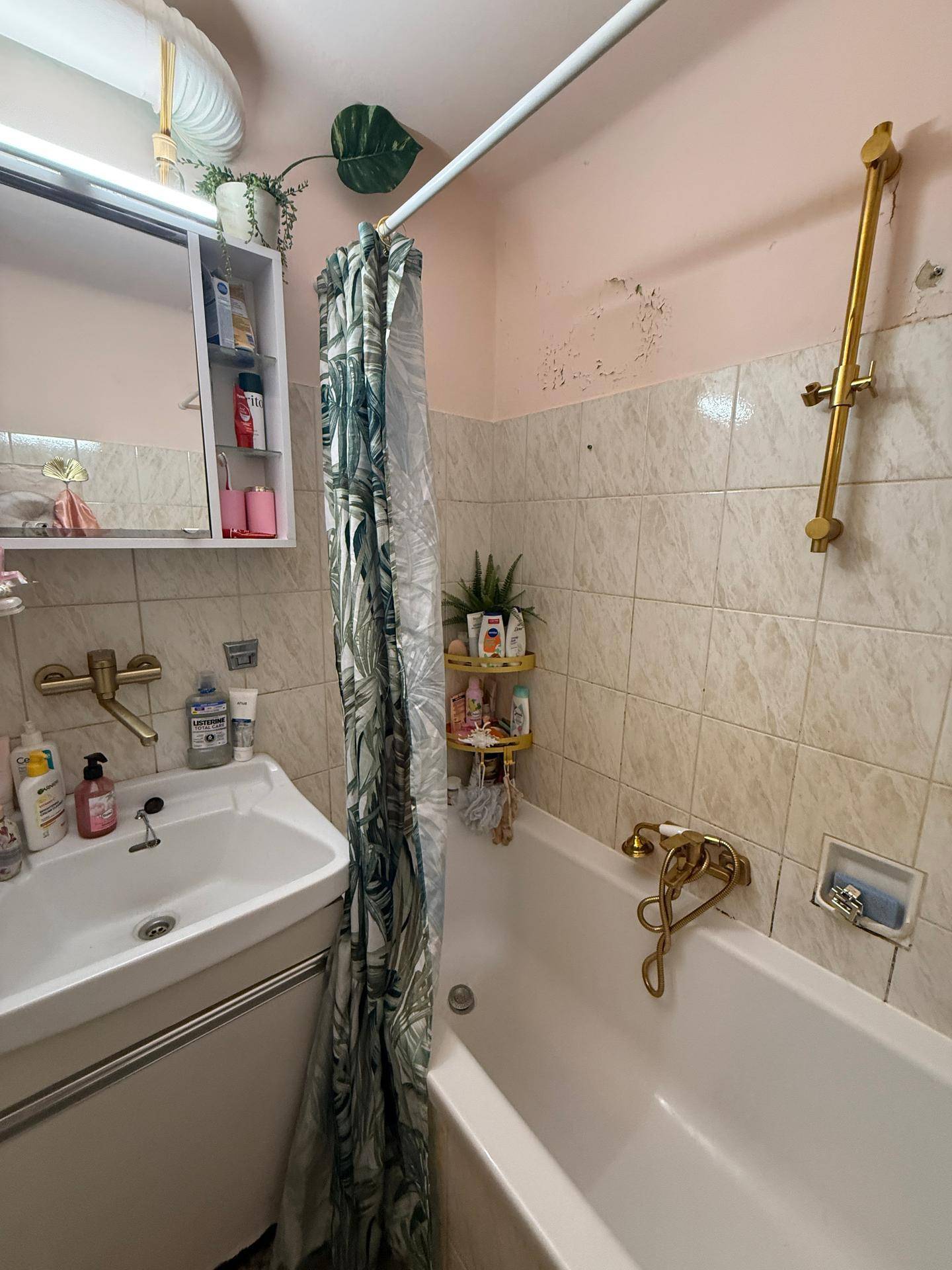 Badezimmer mit Badewanne und Duschkopf, bietet eine funktionale Lösung für die Körperpflege.