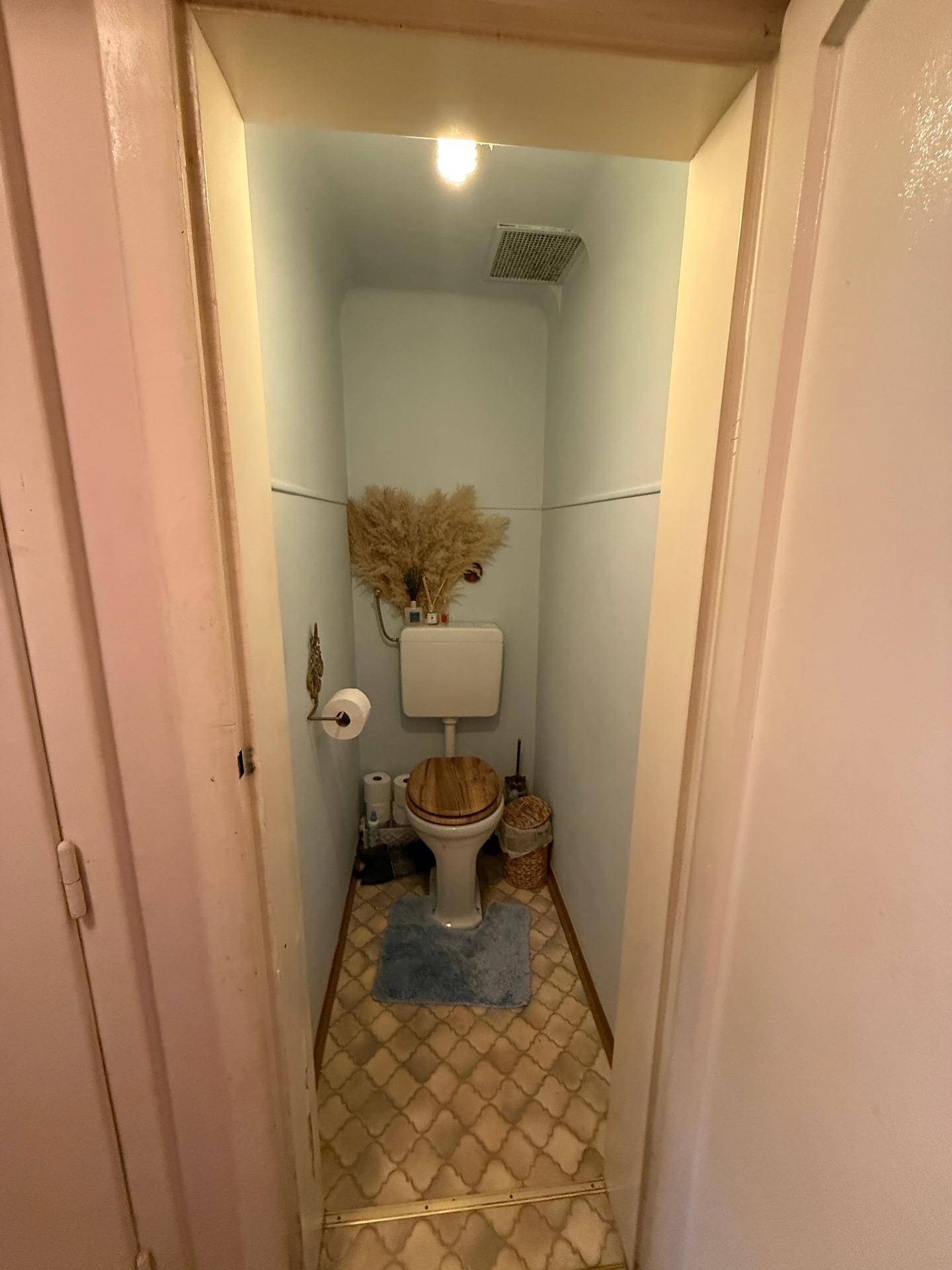 Separates WC mit Toilette und Fliesenboden, bietet eine grundlegende Sanitäreinrichtung.