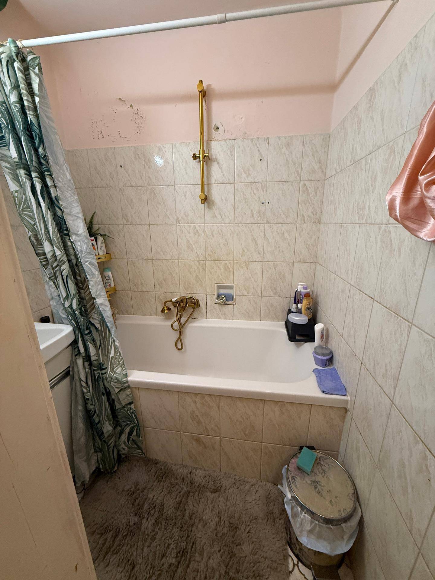 Badezimmer mit Badewanne und Duschvorhang, bietet eine einfache und praktische Einrichtung.