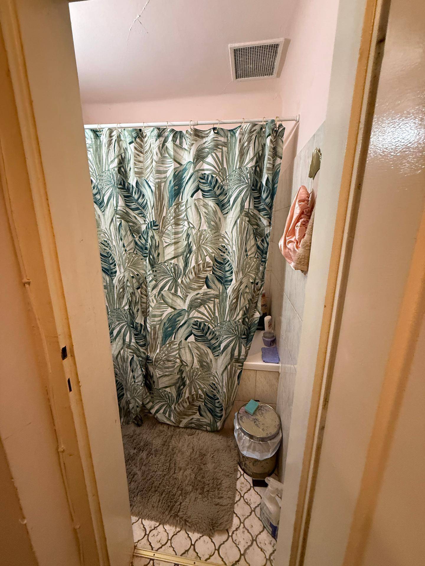 Badezimmer mit Duschvorhang und Fliesen, bietet eine einfache und funktionale Nasszelle.