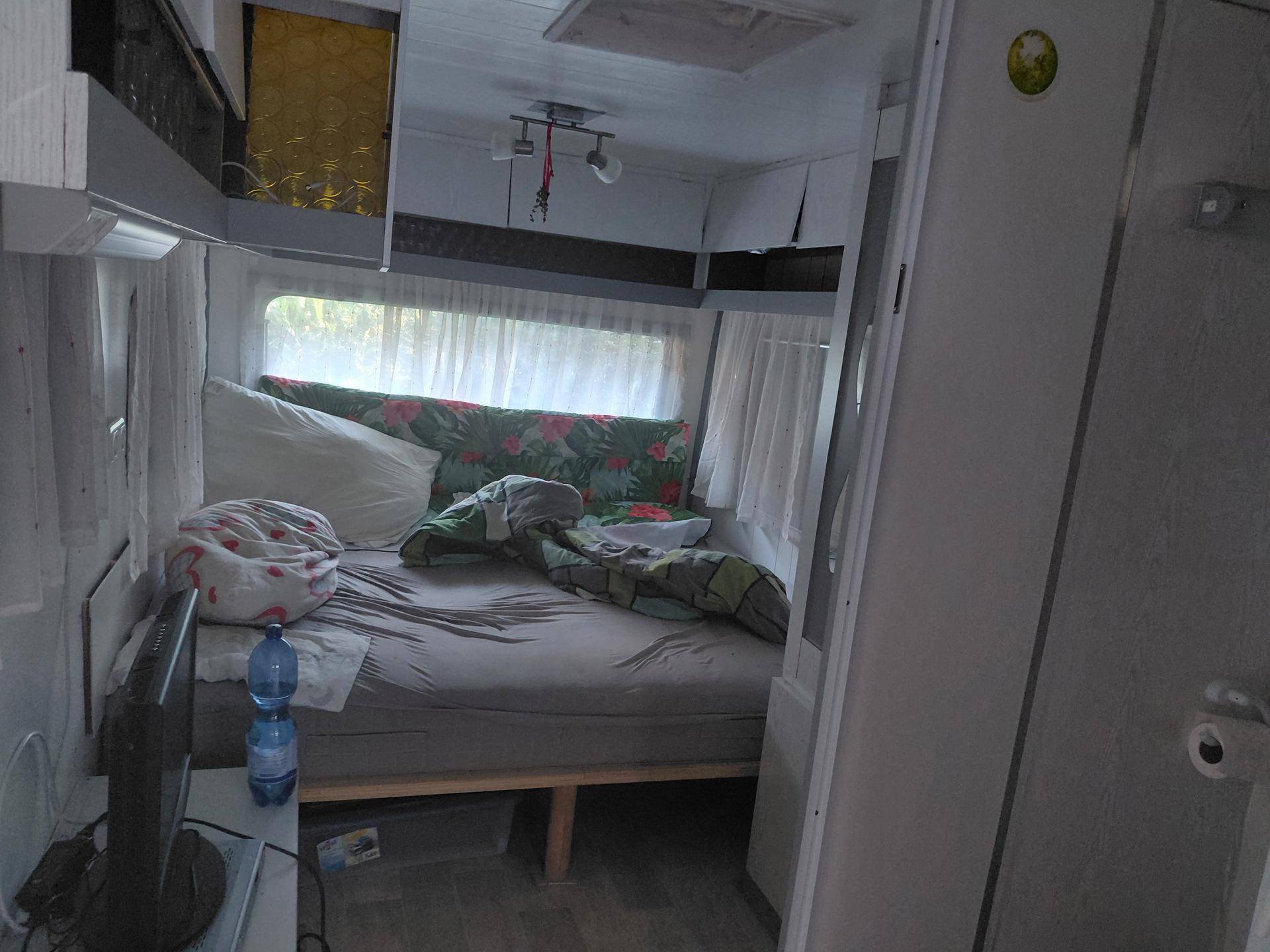 Schlafbereich mit einem Bett und einem Fenster, das für natürliche Belüftung sorgt.