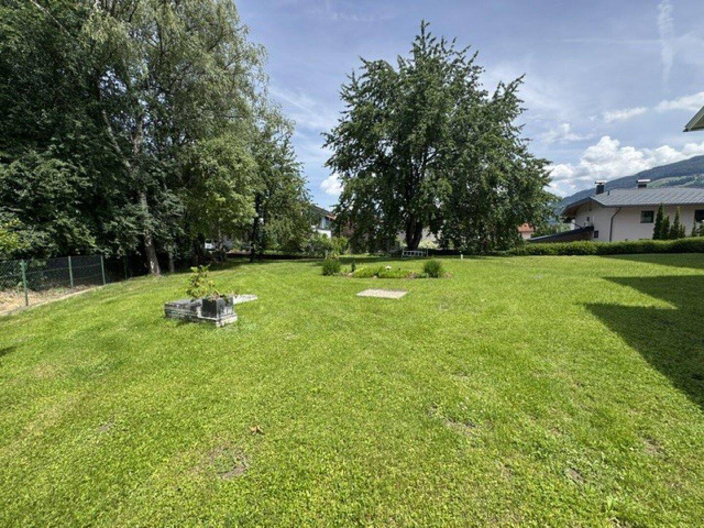 Großer, gepflegter Garten mit weitläufiger Rasenfläche und altem Baumbestand.