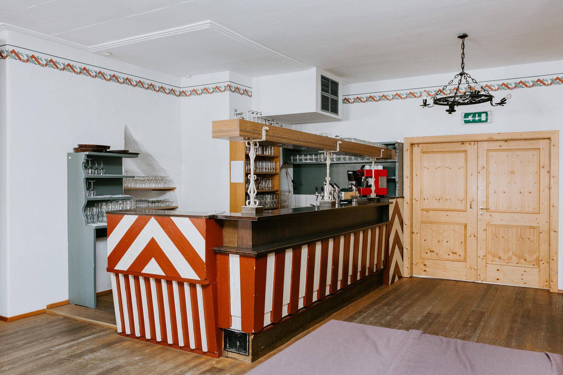 Bar in einem Veranstaltungsraum mit traditionellem Design, Holzelementen und Theke.