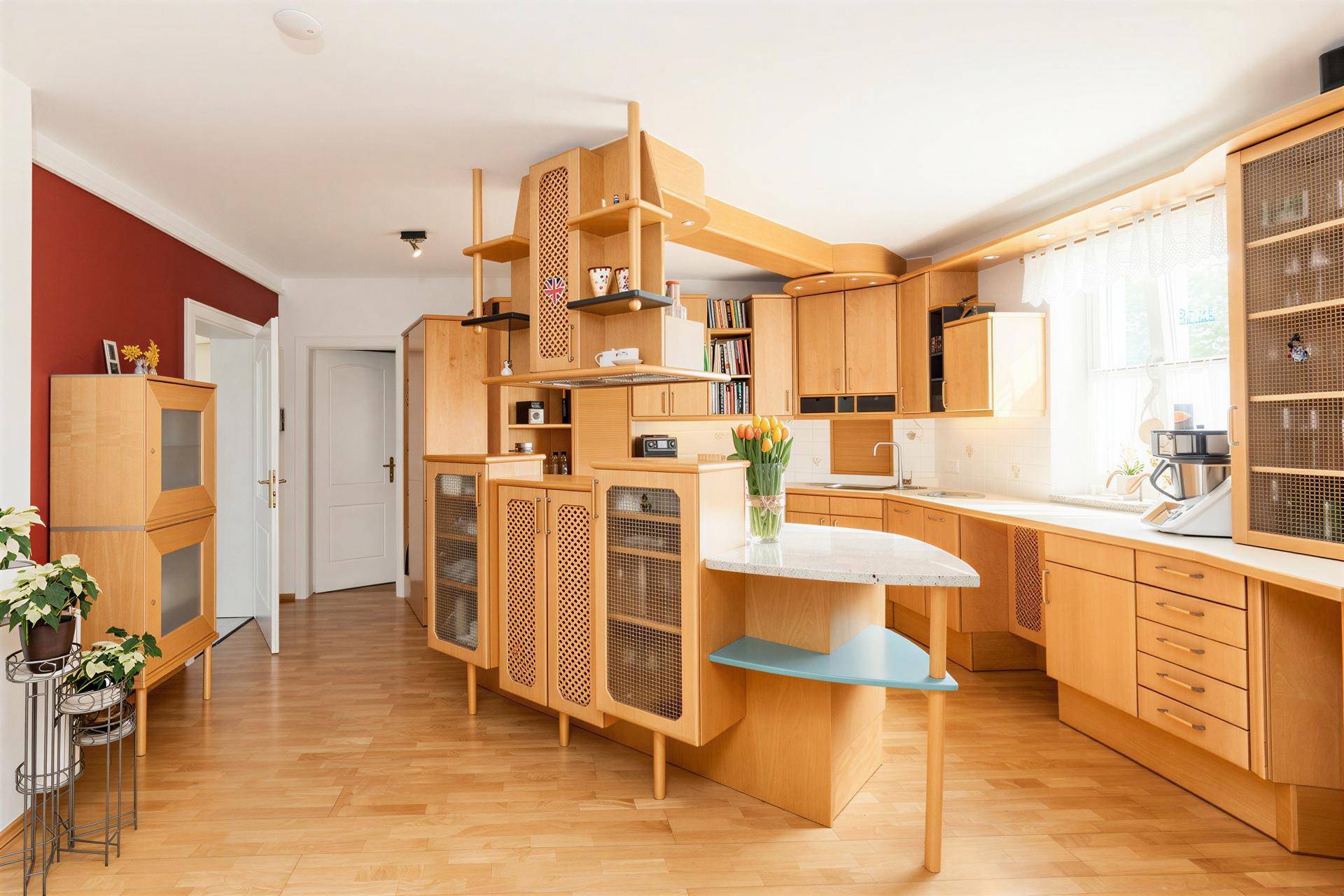 Geräumige Holzküche mit integrierten Geräten, viel Stauraum und Parkettboden.