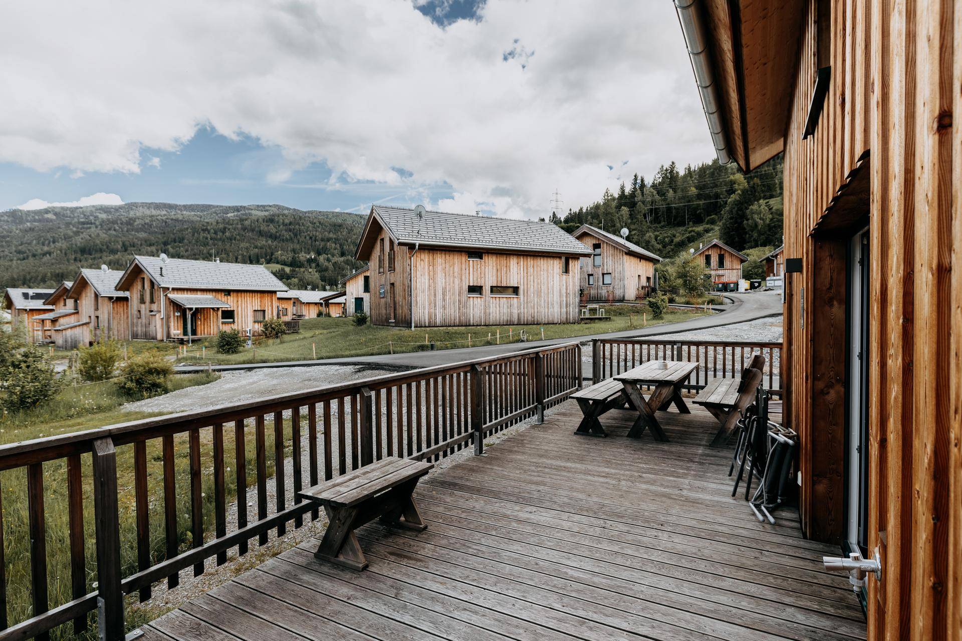 Große Holzterrasse mit Sitzgelegenheiten und weitem Blick auf die Berglandschaft.