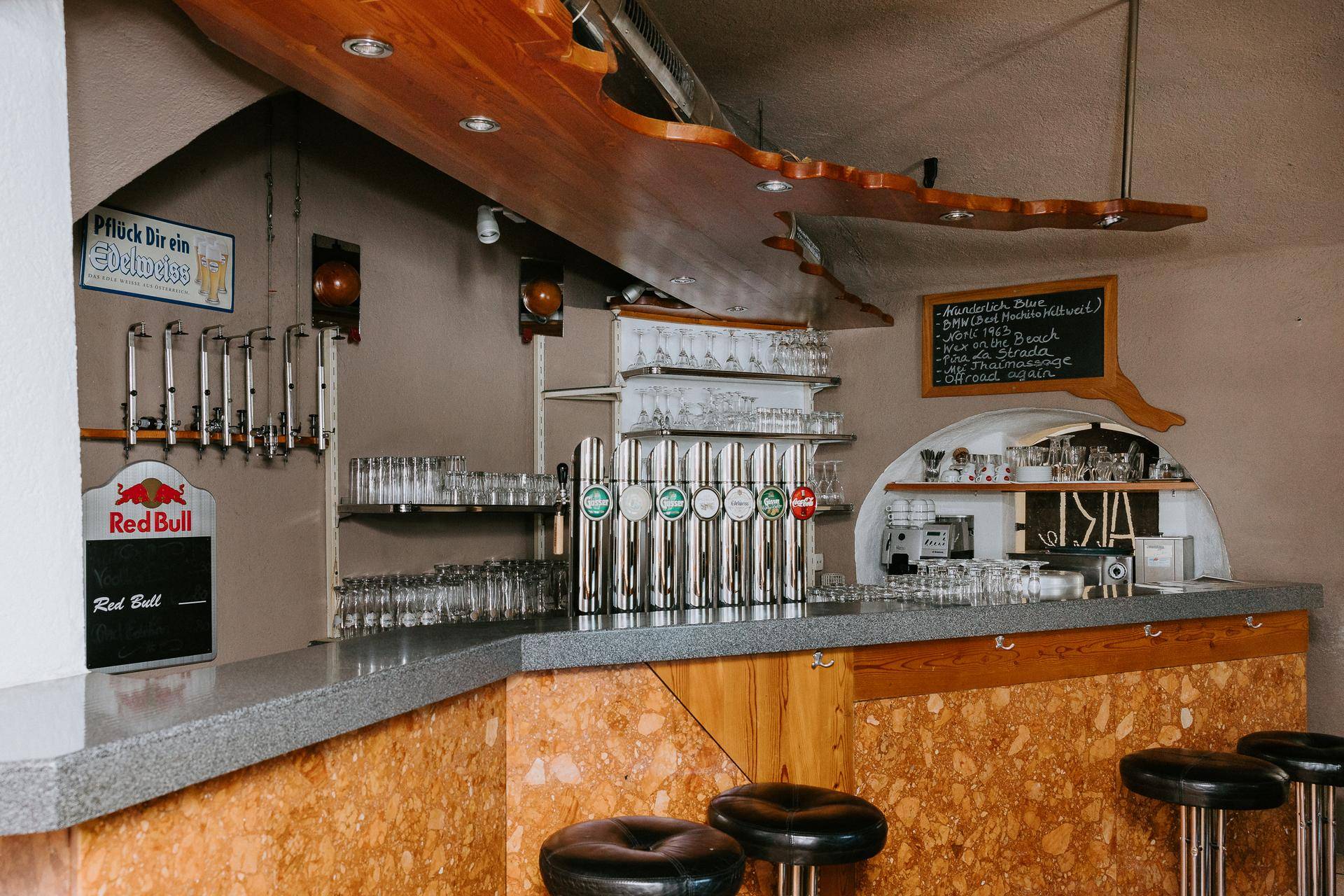 Rustikale Kellerbar mit Zapfanlage, Stehtischen und gewölbter Decke.