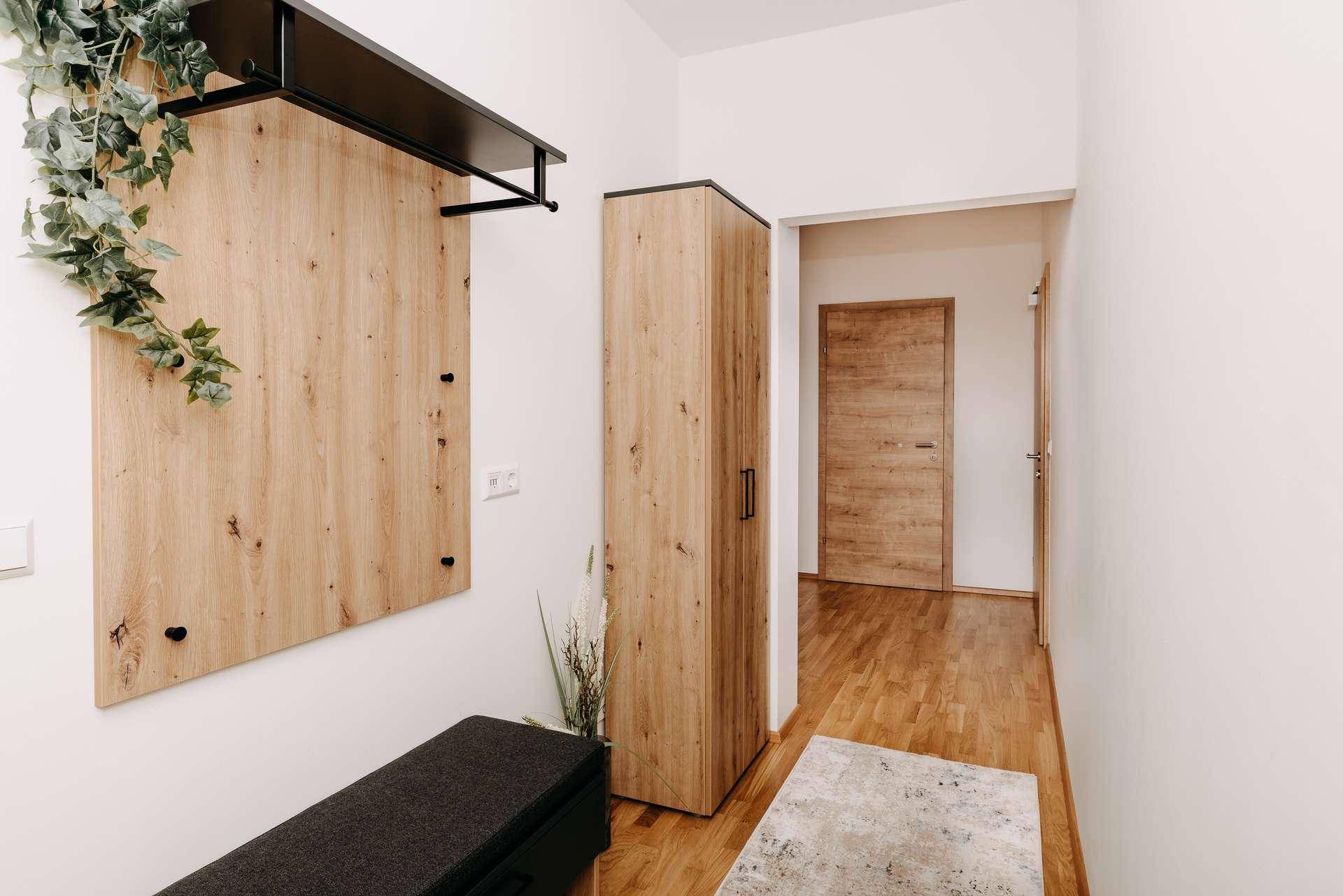 Eingangsbereich mit Holzboden, moderner Garderobe und zusätzlichem Stauraum.
