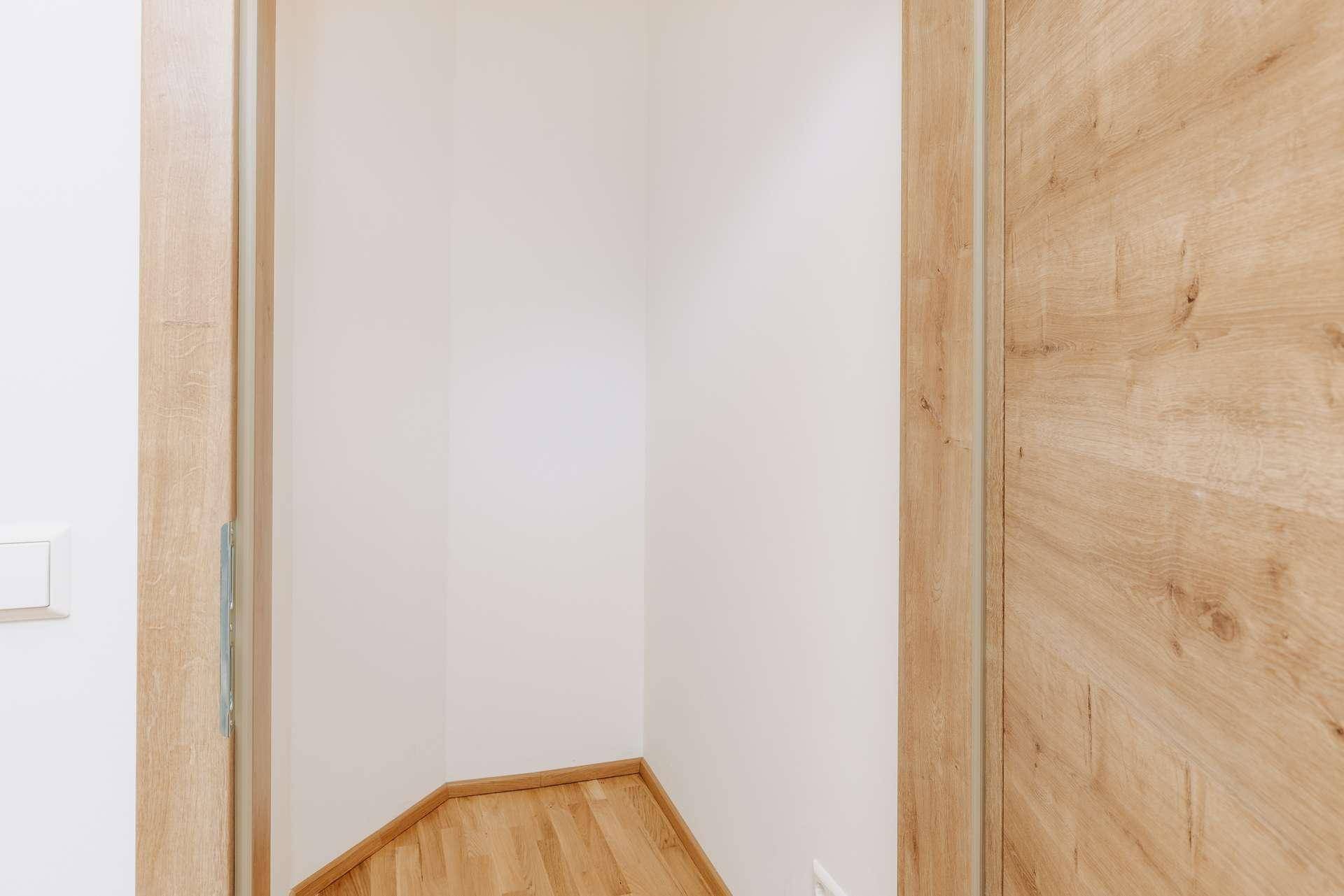 Heller Flur mit Holzboden und Holztüren, der zu weiteren Räumen führt.
