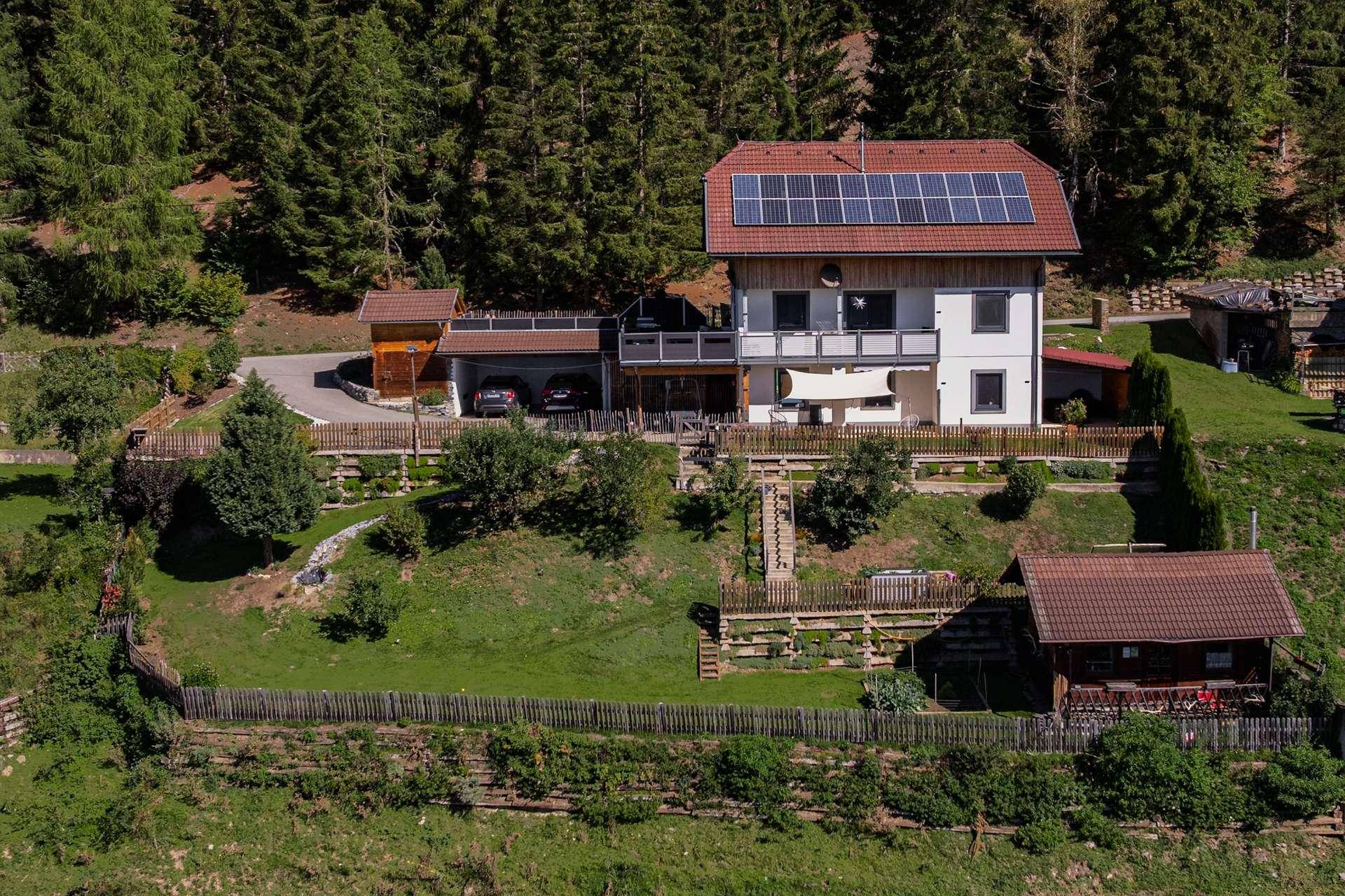Luftaufnahme des Anwesens mit Haus, Solaranlage, Terrasse und weitläufigem Garten.