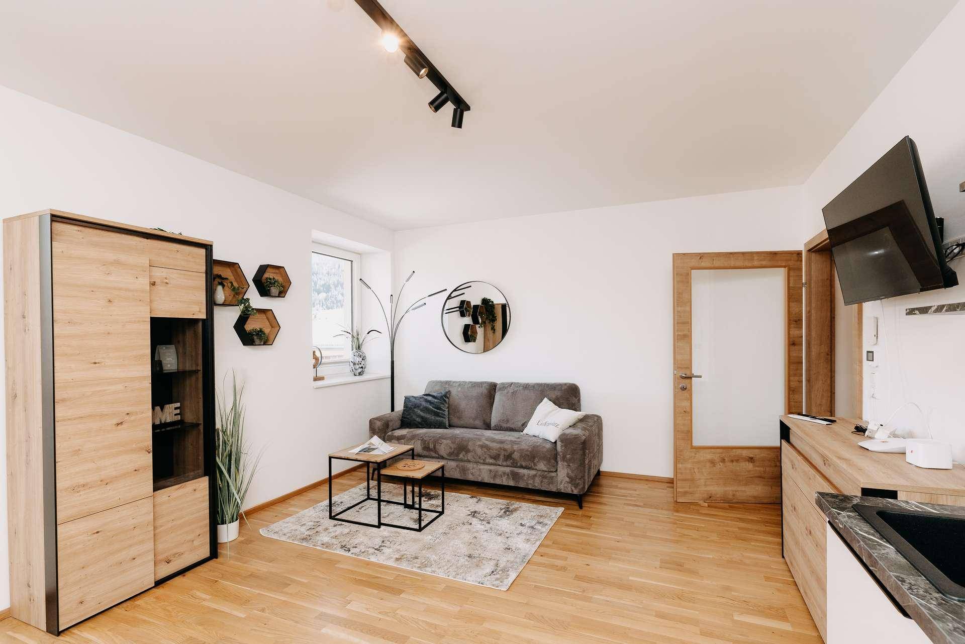 Gemütliches Wohnzimmer mit Sofa, Couchtisch und modernen Wanddekorationen.