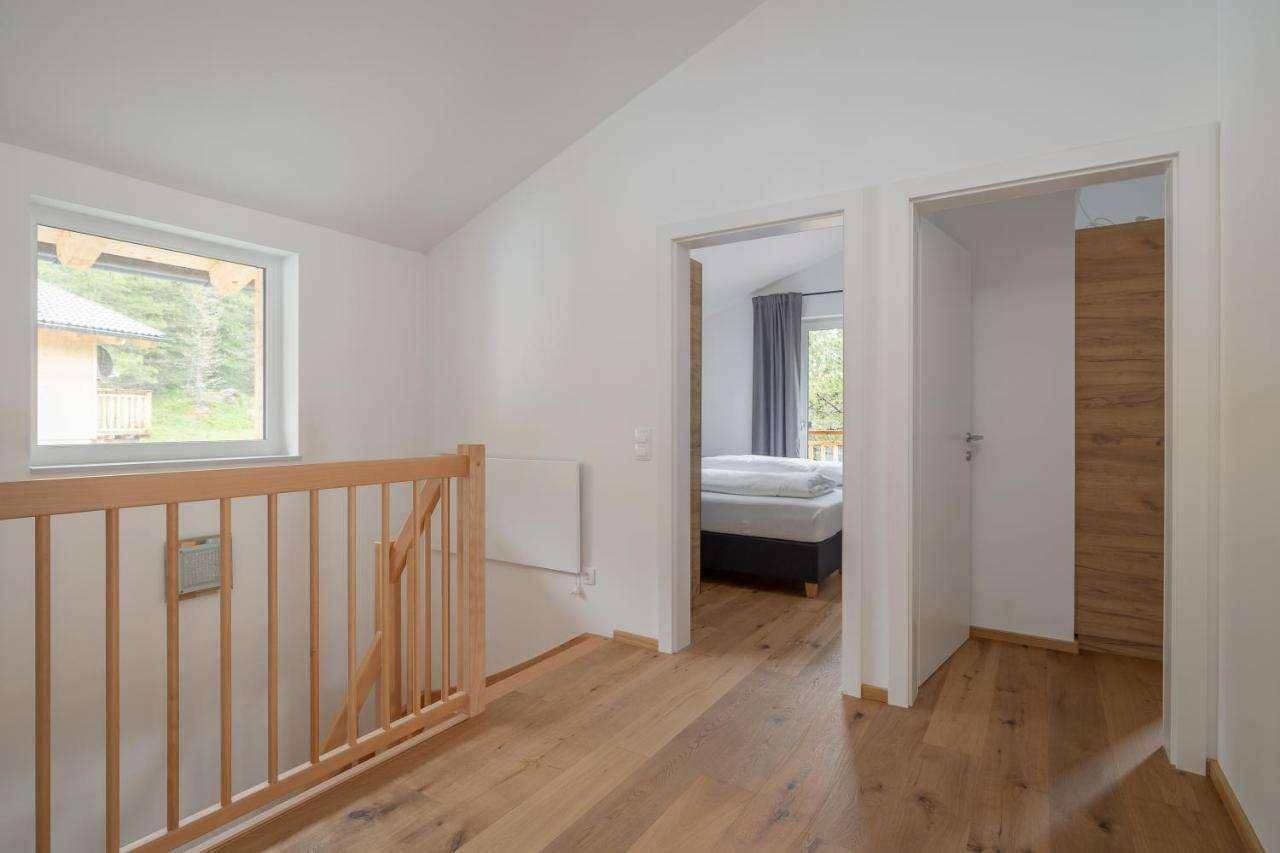 Heller Flur im Obergeschoss mit Holzboden, Holzgeländer und Zugang zu den Schlafzimmern.