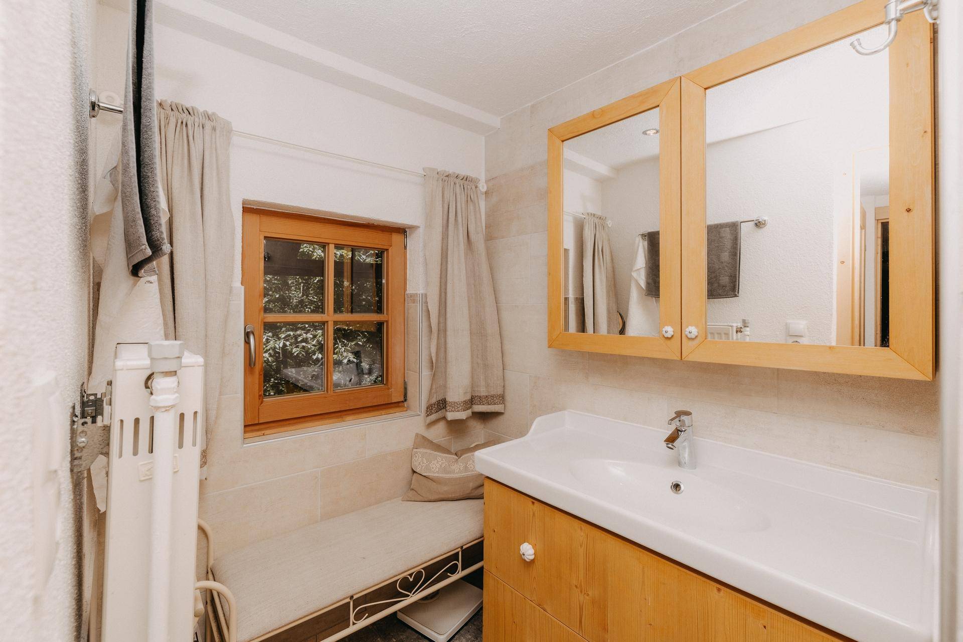 Traditionelles Badezimmer mit Einzelwaschbecken, Spiegelschrank und Fenster.
