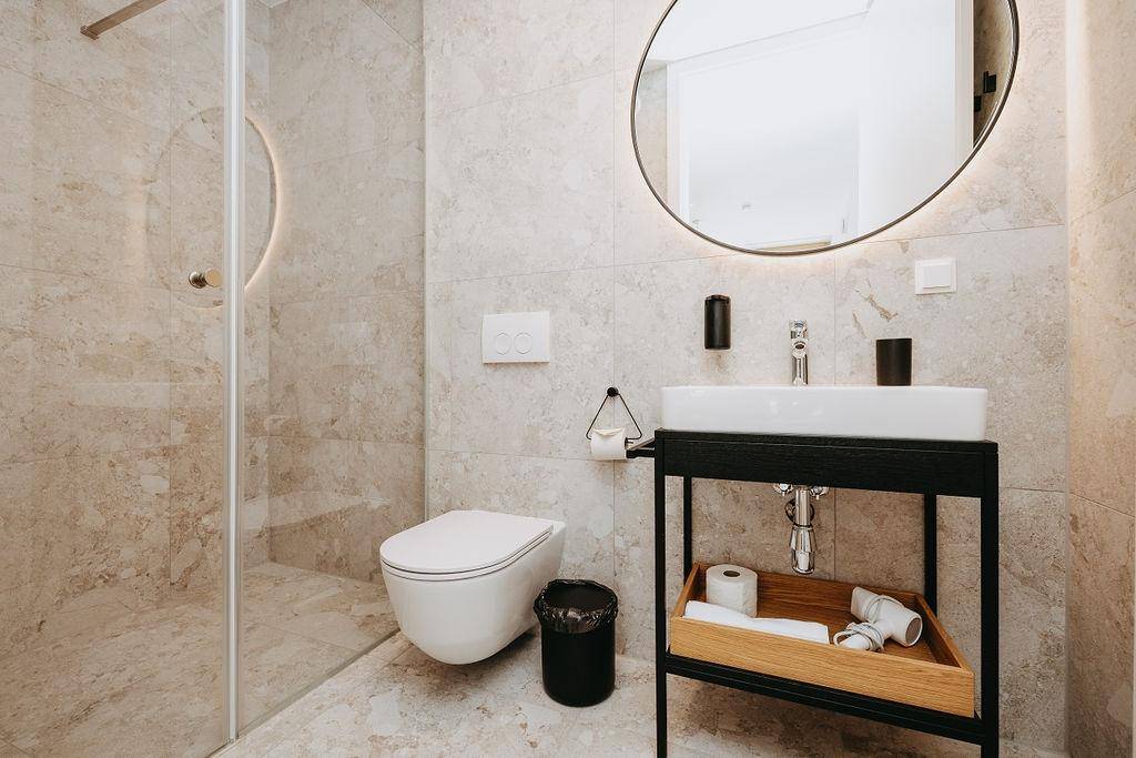 Helles Badezimmer mit begehbarer Dusche, wandhängendem WC und modernem Waschtisch.