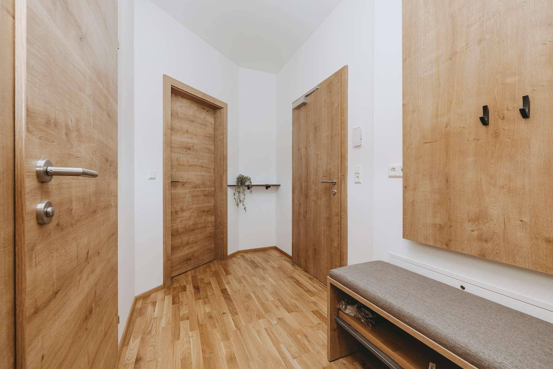 Heller Eingangsbereich mit Holzboden und Garderobe, bietet Zugang zu weiteren Räumen.