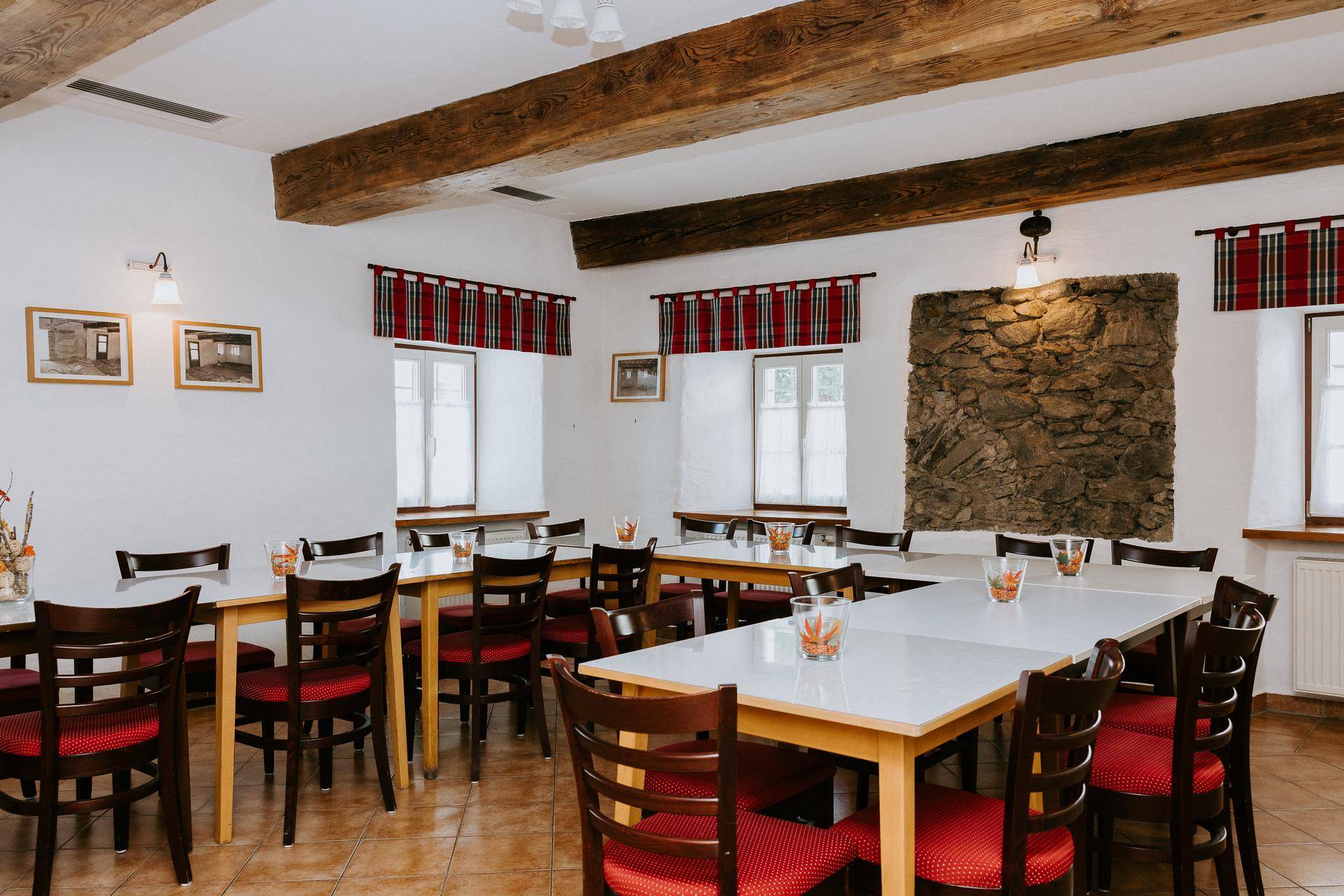 Geräumiger Speisesaal mit Holzbalken, Steindekor und vielen Tischen für größere Gruppen.