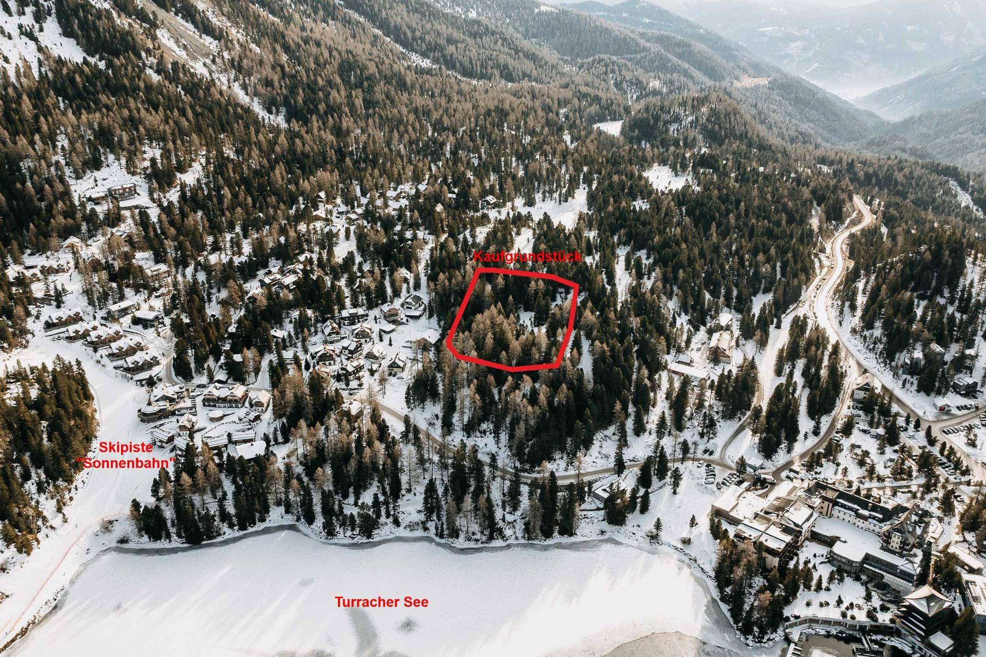 Übersicht aus der Luft mit markiertem Kaufgrundstück, See und Skipiste in der Turracher Höhe.