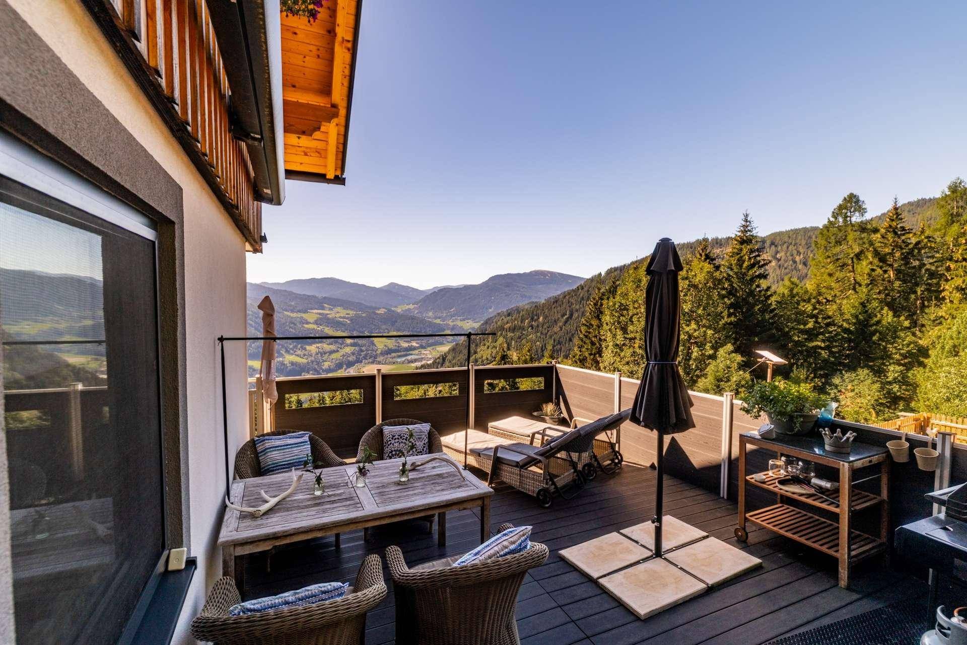 Große Terrasse mit Sitzgelegenheiten, Grillbereich und atemberaubendem Bergblick.