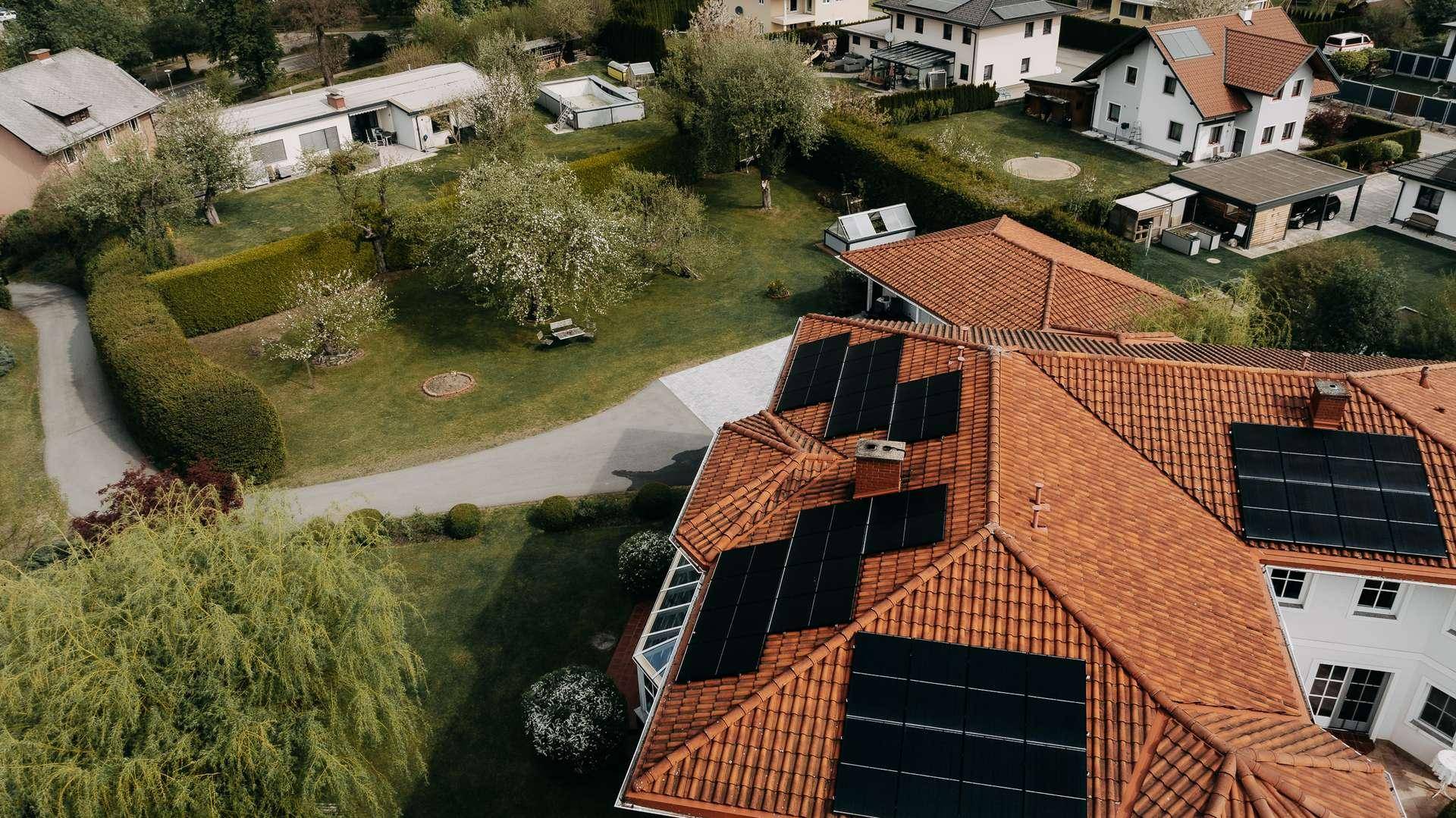 Dachansicht des Hauses mit Photovoltaikanlage und Blick auf die umliegende Wohnsiedlung.