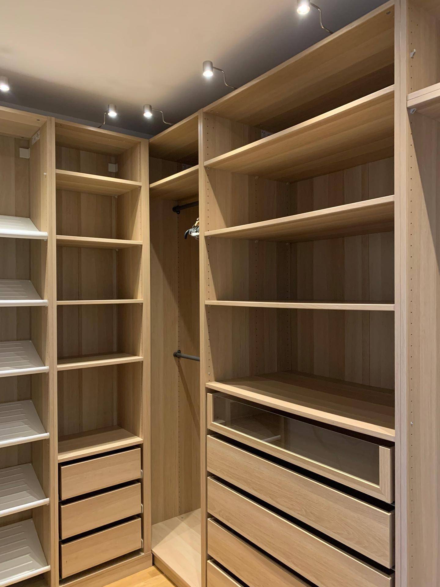Geräumiger begehbarer Kleiderschrank mit vielen Regalen und Schubladen.