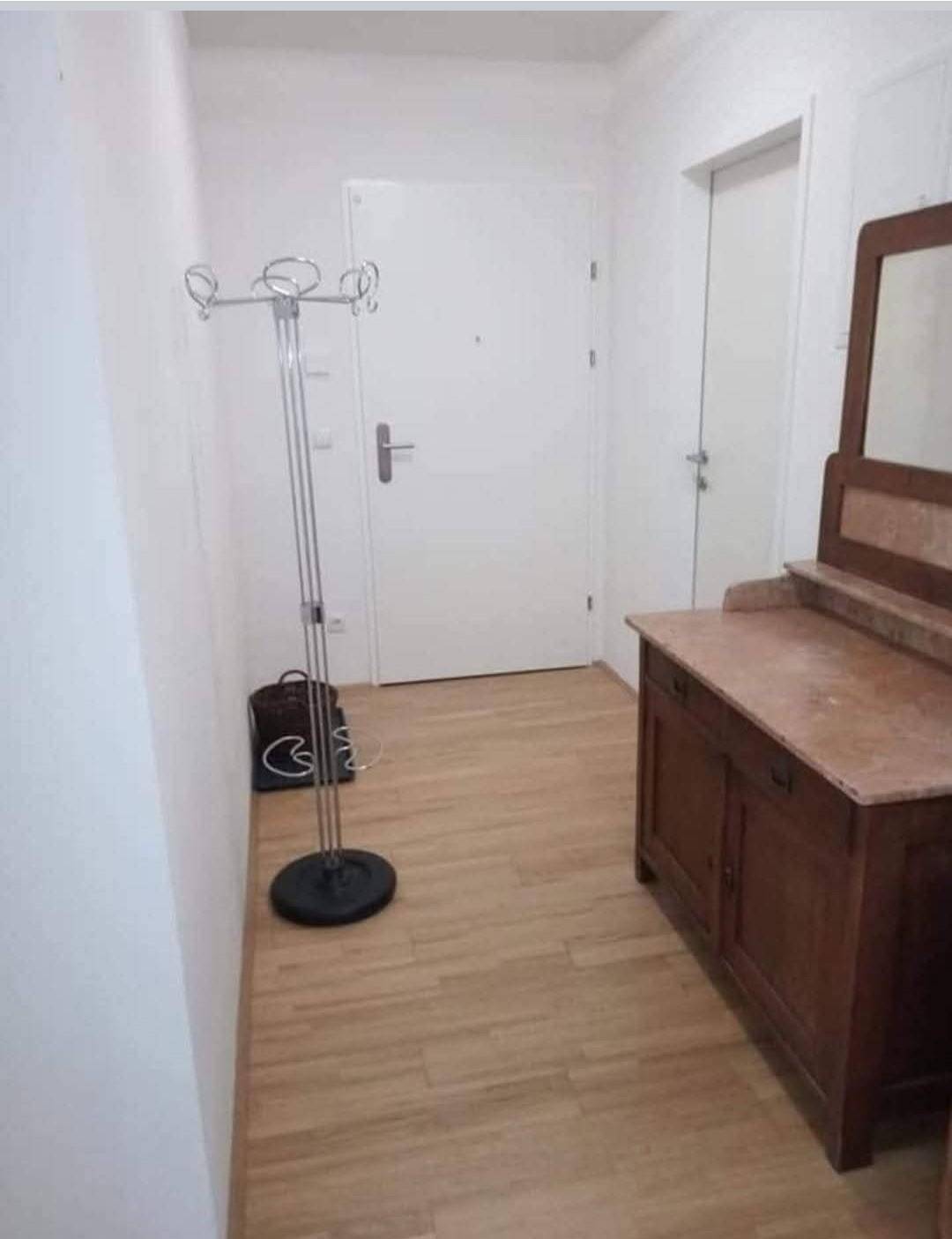 Eingangsbereich mit Garderobenständer, Kommode und hellem Laminatboden.