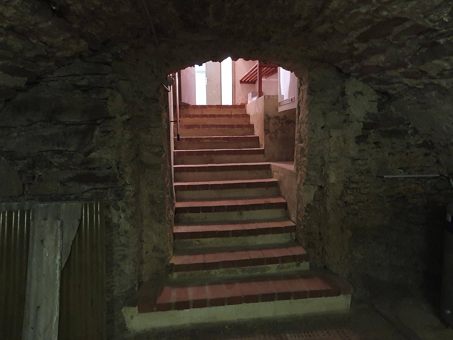 Treppenaufgang aus einem historischen Gewölbekeller mit robusten Steinwänden.