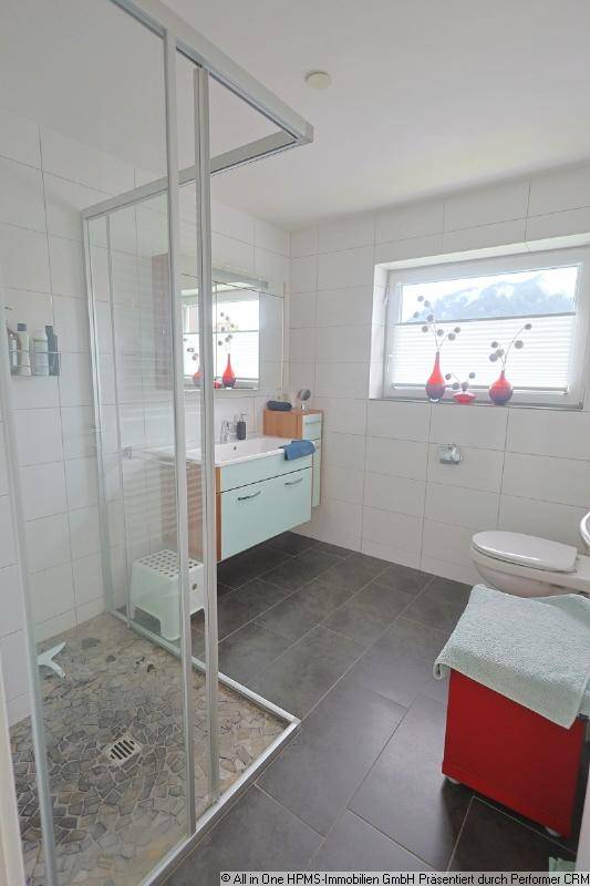 Modernes Badezimmer mit ebenerdiger Dusche, Fenster und dunklen Bodenfliesen.