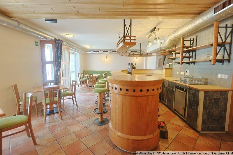 Geräumiger Barbereich mit Holzelementen, gefliestem Boden und Sitzgelegenheiten in traditionellem Stil und natürlichem Licht.