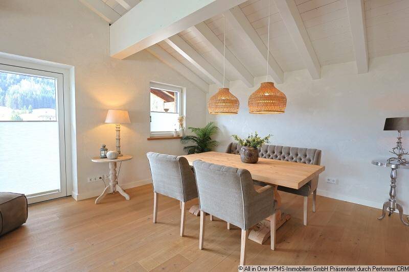 Geräumiger Essbereich mit Holztisch, gepolsterten Stühlen und Zugang zu einem Außenbereich.