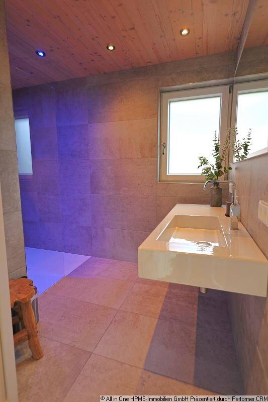 Helles Badezimmer mit Fenster, schwebendem Waschbecken und modernen Fliesen.