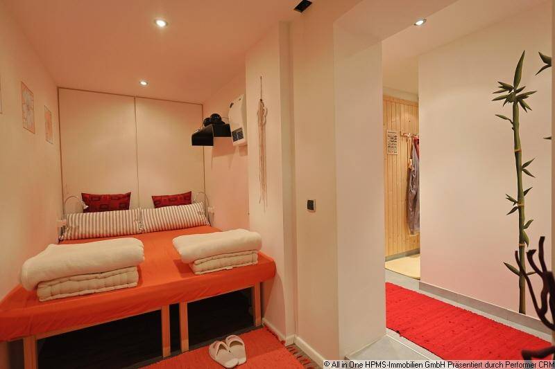 Kleiner Raum mit Bett und Zugang zu einem Wellnessbereich mit Sauna.