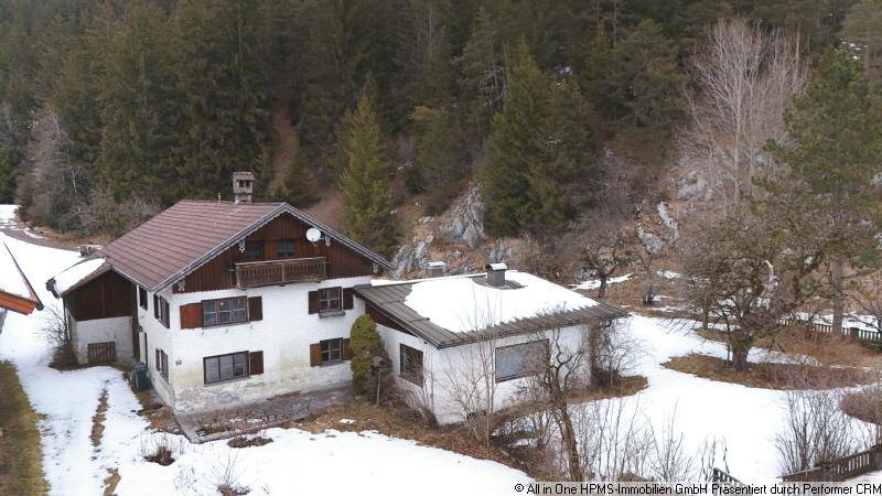 Luftaufnahme des Anwesens im Winter, umgeben von Schnee und bewaldeten Bergen.