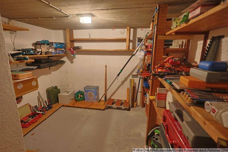 Kellerraum mit Betonboden und Regalen, ideal zur Lagerung verschiedener Gegenstände.