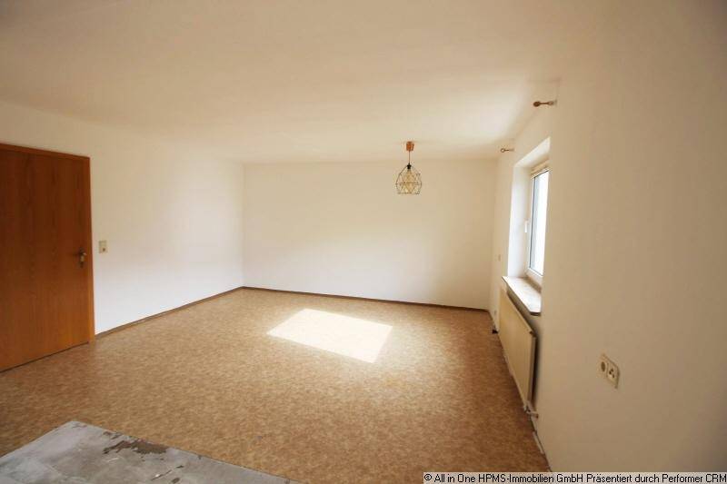 Leerer Raum mit Linoleumboden und Fenster, bereit zur individuellen Gestaltung.