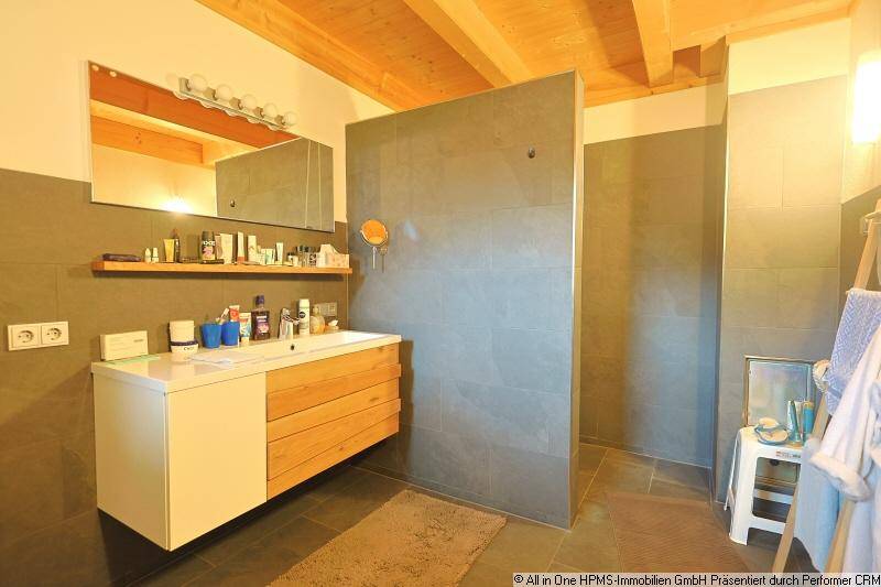 Modernes Badezimmer mit begehbarer Dusche, stilvollem Waschtisch und grauen Fliesen.