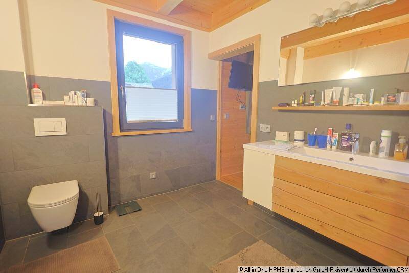 Helles Badezimmer mit modernem Waschtisch, wandhängendem WC und Fenster für Tageslicht.