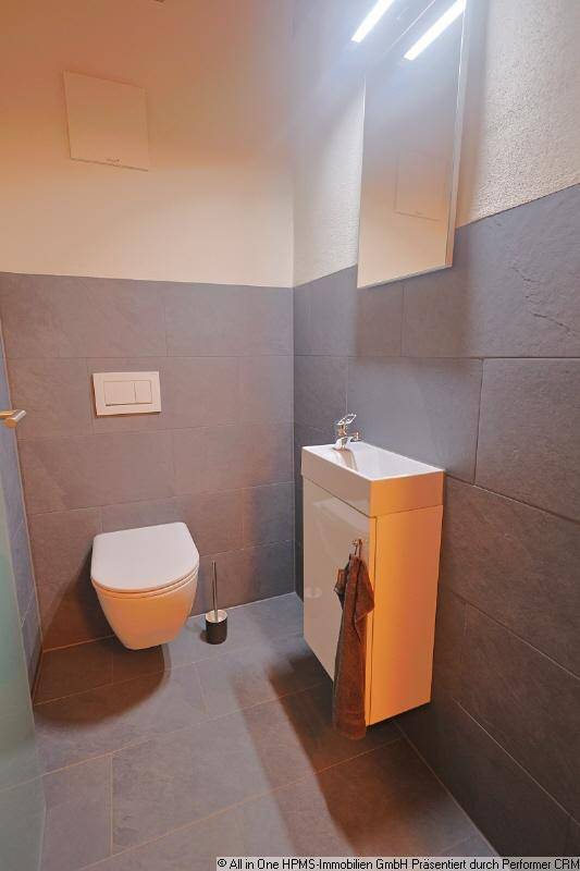 Kleines, modernes Gäste-WC mit wandhängendem WC und kompaktem Waschtisch.