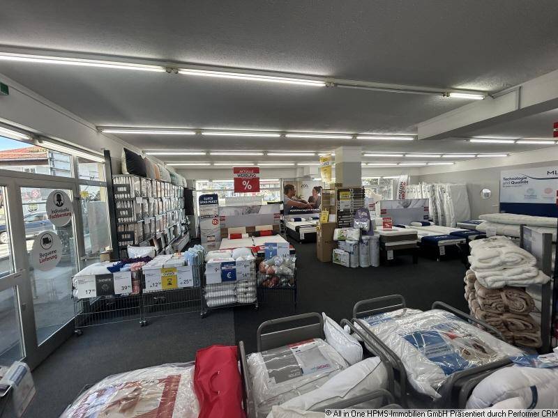 Blick in das Matratzengeschäft mit weiteren Produkten und einem Eingangsbereich mit Tageslicht.