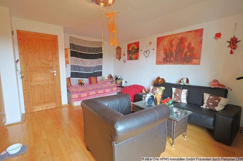 Geräumiger Wohnraum mit Tagesbett, Sofa und Holzboden, ideal für Entspannung und Gäste.