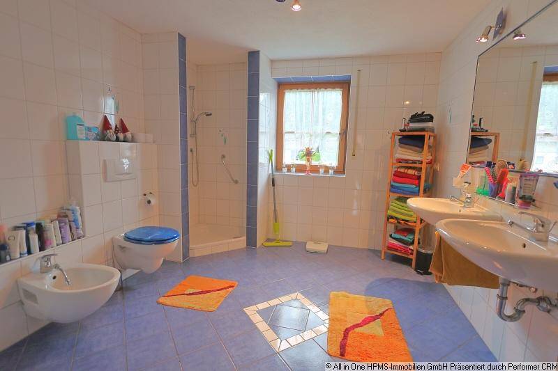 Funktionales Badezimmer mit Doppelwaschbecken, Dusche, Badewanne und farbigen Akzenten in Blau und Weiß.