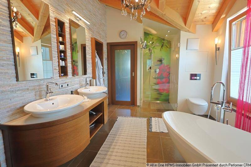 Modernes Badezimmer mit freistehender Badewanne, Doppelwaschbecken und Holzbalkendecke.